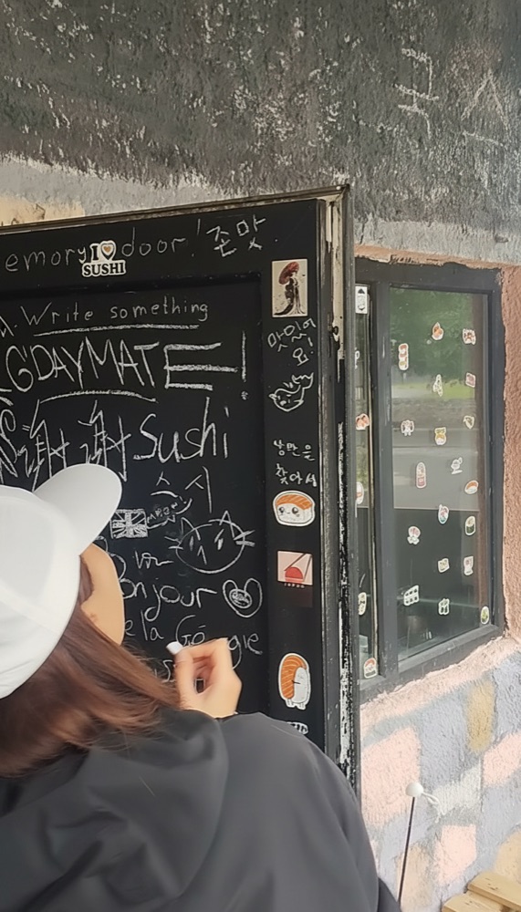 Guests writing on the chalkboard memory door